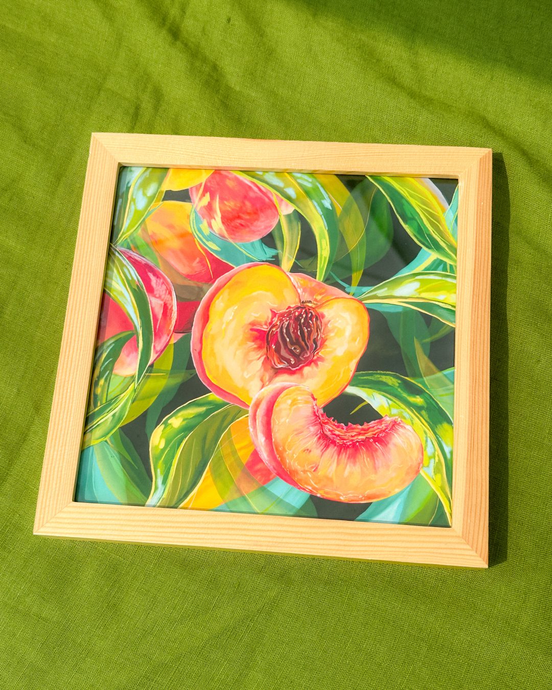 Framed peach painting on green linen