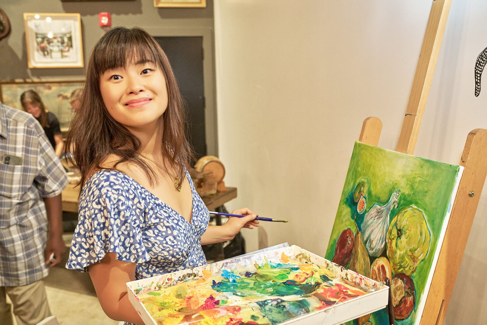 Painting a fruit and vegetable canvas with a full palette at an event