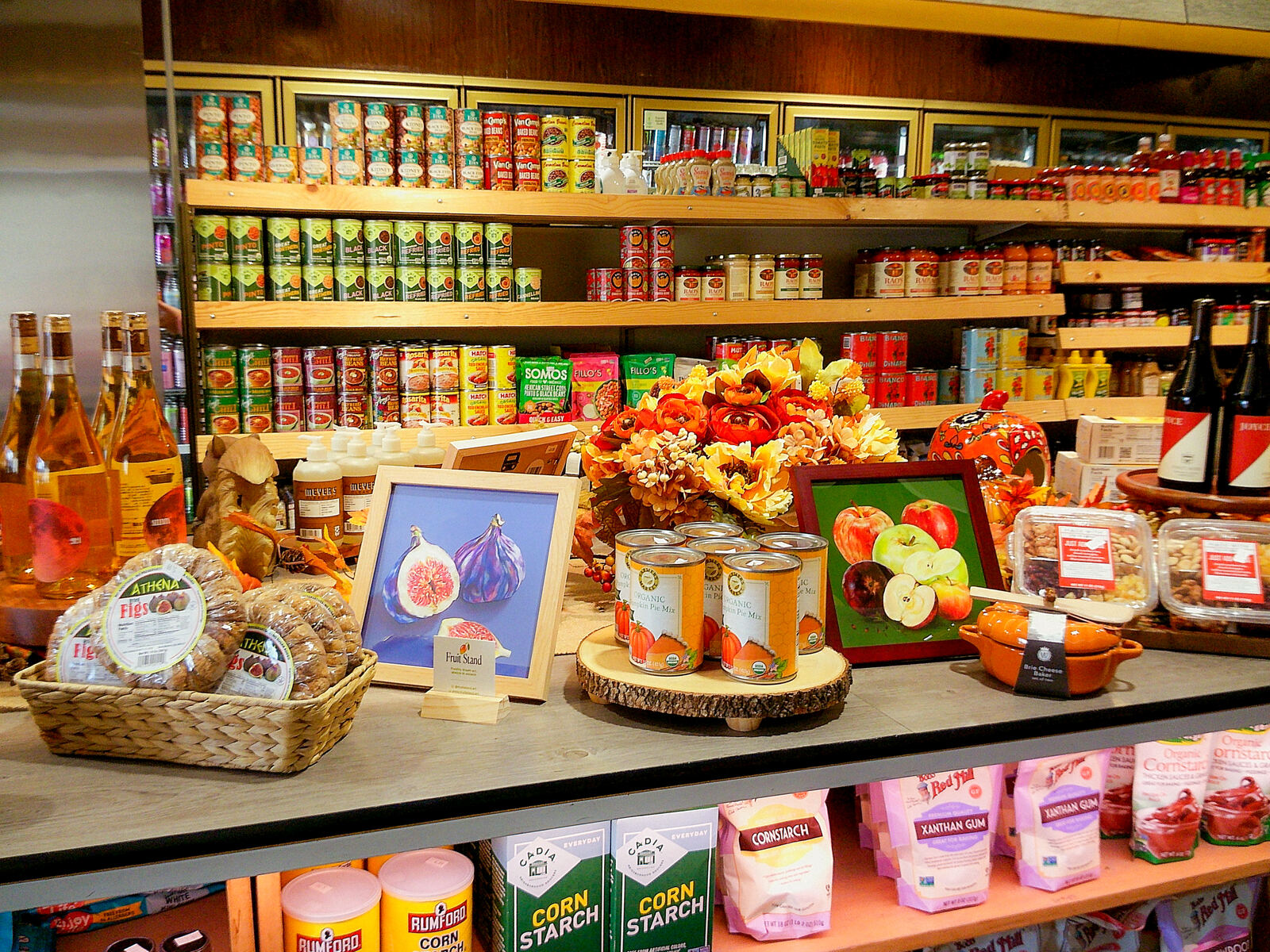 A framed Fruit Stand fig print on a shop shelf at La Tropicana